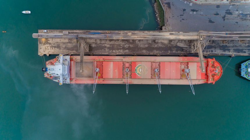 Vista aérea de um navio de carga atracado em um porto brasileiro.